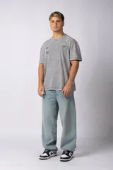 Remera de algodón con efecto lavado ácido en color gris, de corte holgado y manga corta. Presenta estampados gráficos minimalistas en el pecho y cuello redondo acanalado.