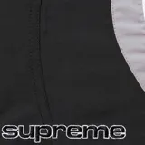 Short de baño Supreme de corte deportivo, color negro con paneles laterales curvos en gris y blanco. Cuenta con cintura elástica y logo de la marca bordado en la parte inferior.
