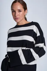 Sweater Bremer con cuello redondo y mangas largas ligeramente amplias. Diseño a rayas horizontales en color crudo y negro.