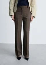 Pantalon de vestir color marrón, de corte recto y tiro medio, con bolsillos laterales y cierre oculto. Presenta una textura fluida y costuras frontales marcadas.