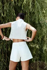 Short de jean blanco con tiro medio, cinco bolsillos y bordados florales en los laterales.