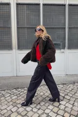 Jersey de punto color rojo vibrante, con cuello barco y manga larga. Presenta un calce amplio estilo capa con bajo asimétrico y aberturas laterales.