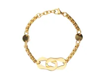 Pulsera dorada de acero con dije central entrelazado en forma ovalada calada.