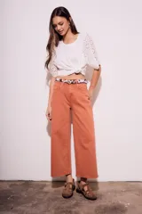 Pantalón jean color ladrillo, de corte ancho y tiro medio.