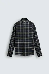 Camisa relaxed fit de franela de algodón, con diseño a cuadros en tonos azul marino, verde y blanco. Cuenta con cuello camisero, manga larga con puños abotonados, bolsillos de parche en el pecho y cierre frontal con botones.