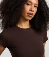Blusa básica de manga corta y cuello redondo, confeccionada en malla rib de algodón con ajuste ceñido al cuerpo.