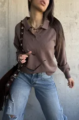 Sweater de punto color chocolate con diseño de rombos texturizados, cuello polo con botones y mangas largas.