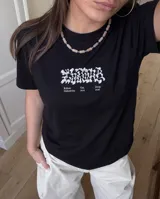 Remera negra de corte regular con estampa gráfica en la espalda que combina tipografía clásica y texturizada con la frase Cultura de Barrio.