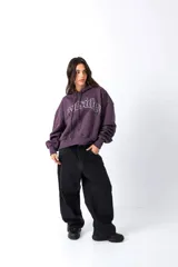 Hoodie color vino con capucha y bolsillo canguro frontal. Presenta un estampado en el pecho con la palabra "Outsider" en tipografía universitaria blanca con borde.