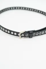 Cinturón fino de cuero sintético color celeste, con perforaciones metálicas a lo largo de toda la tira y hebilla metálica plateada.