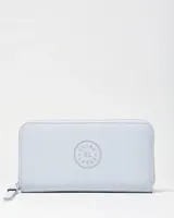 Billetera de cuero sintético color celeste, con cierre perimetral y tirador de cierres con logo grabado. Presenta un aplique circular en relieve con la inscripción Extra Large en el centro.