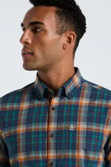 Camisa de manga larga para hombre, con cuello abotonado y bolsillo en el pecho. Presenta un estampado de cuadros (tartán) en tonos azul marino, verde azulado, naranja quemado y beige.