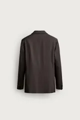 Blazer regular fit de Zara, confeccionado en lana de origen italiano, de color azul marino. Cuenta con cuello de solapas de muesca, cierre frontal de dos botones, bolsillos con solapa en la cadera y un bolsillo de vivo en el pecho.