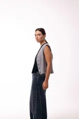 Chaleco tejido de punto con escote en V y cierre frontal con botones. Presenta una silueta recta y un diseño minimalista.