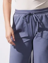 Pantalón jogger color crema, de corte ancho, con pretina elastizada y lazo de ajuste.