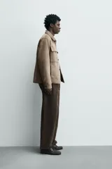 Sobrecamisa regular fit color verde oscuro, confeccionada en tejido efecto ante. Cuenta con cuello solapa, manga larga con puño abotonado, bolsillos de plastrón con solapa en el pecho y bolsillos de vivo en la cadera. El cierre es frontal con botonadura.