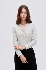 Blusa de viscosa color bordó, con cuello en V, cierre frontal parcial con botones, mangas tres cuartos y bolsillo aplicado en el pecho.