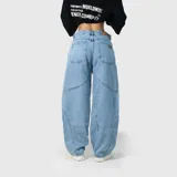 Pantalón de jean estilo ultra baggy con diseño de paneles curvos en las piernas. Presenta un lavado claro, bolsillos traseros amplios y costuras reforzadas que definen su silueta holgada y voluminosa.