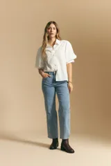 Jean de corte recto y tiro medio, confeccionado en denim elastizado de color negro. Presenta un diseño clásico con cierre de botón y cremallera, bolsillos laterales y traseros, y ruedo con terminación deshilachada.