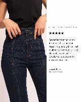 Jean de tiro alto en denim azul oscuro, con corte semi Oxford y diseño de recortes verticales con pespuntes visibles en el frente.