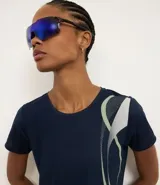 Remera deportiva de microfibra color azul marino, con cuello redondo, mangas cortas y estampa lateral con diseño de ondas en tonos verde claro y gris.