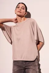 Sweater rosa de lurex con mangas cortas amplias y cuello redondo.