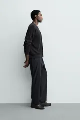 Pantalón de vestir regular fit color negro, confeccionado en tejido con mezcla de lana y elasticidad. Cuenta con cintura elástica, bolsillos frontales, bolsillos traseros de vivo con botón, y cierre frontal con cremallera y botón.