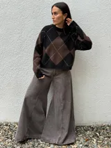 Sweater de punto con diseño de rombos en tonos bordó y beige, cuello redondo y mangas largas con puños acanalados.