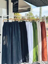 Pantalón tipo palazzo de corte amplio y fluido, confeccionado en lino natural. Presenta cintura elástica con cordón ajustable y bolsillos laterales.