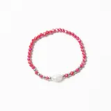 Pulsera elástica compuesta por cuentas de cristal facetado en color rojo, intercaladas con pequeñas esferas metálicas plateadas y una perla central de forma irregular.