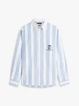 Camisa de corte clásico de puro algodón Oxford, con diseño de rayas verticales en color celeste y blanco. Cuenta con cuello abotonado, bolsillo frontal de parche con un escudo bordado y mangas largas con puños redondeados.