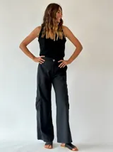 Pantalón cargo negro de corte ancho, con bolsillos laterales y traseros con solapa.