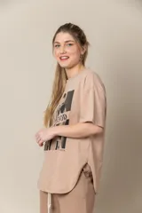 Remera blanca de algodón con cuello redondo y mangas cortas. Estampa frontal con fotografía en blanco y negro de una mujer con toalla en la cabeza y lentes de sol.