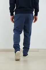 Pantalón jogging de corte recto, confeccionado en tejido circular con cintura elástica y cordón ajustable al tono. Presenta bolsillos laterales tipo parche.