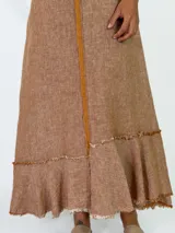 Vestido largo sin mangas, con escote en V, corte holgado y detalles de volados con flecos en el ruedo.