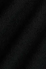 Top capa negro de corte holgado en punto texturizado suave, con escote bote y mangas capa amplias.