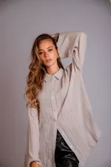 Camisa rosada con detalles de broderie en la parte delantera y mangas anchas.