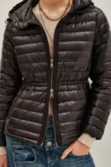 Campera puffer negra con capucha, cierre frontal con doble cremallera y diseño entallado en la cintura.