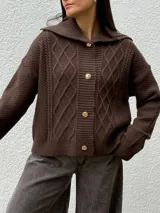 Cardigan de punto color marrón con diseño de rombos y textura, cuello amplio y cierre frontal con botones dorados.