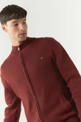 Campera tejida de algodón con cierre frontal completo, cuello alto y puños acanalados. Presenta un logo bordado en el pecho y bolsillos laterales.