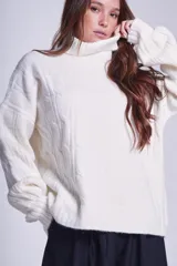 Sweater tejido color crudo con cuello alto y diseño de ochos.