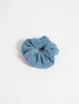 Gomita de pelo scrunchie celeste de tela simil corderito.