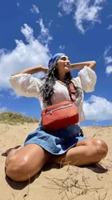 Bandolera de diseño moderno y funcional, confeccionada en nylon color marrón claro. Cuenta con múltiples compartimentos con cierre metálico, herrajes plateados y una correa ancha ajustable con detalle de marca.