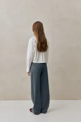 Jean de tiro medio con calce amplio, piernas rectas de inspiración wide leg y diseño de cinco bolsillos con sutiles rayas verticales.