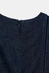 Vestido midi de denim azul oscuro, con escote en V, mangas cortas y detalles de entredoses en el escote y la cintura. Cuenta con cierre trasero con cremallera oculta.