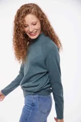 Sweater de punto color verde azulado, con cuello alto y mangas largas.