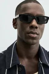 Sobrecamisa de hombre, corte relajado, color azul marino con rayas verticales blancas. Presenta cuello solapa, manga larga con puños abotonados, bolsillos de parche delanteros y cierre frontal de botones.