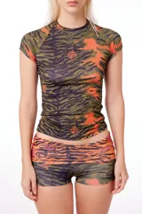 Remera anatómica de manga corta, confeccionada en tejido de poliéster con estampado de tigresa en tonos verde, naranja y negro.