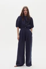 Pantalón sastrero de lino color azul marino, de corte wide leg, tiro alto con pinzas en la parte delantera y bolsillos laterales.