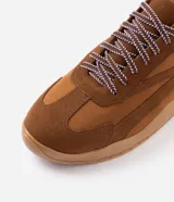 Championes estilo retro runner Satinato de color marrón, con capellada en tejido y recortes de gamuza sintética. Cuentan con cordones bicolores, detalle en lila en el talón y suela texturizada.